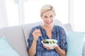 Pretty blonde woman eating bowl of salad Royalty Free Stock Photo