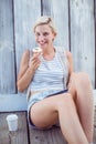 Pretty blonde woman holding cupcake and using her tablet Royalty Free Stock Photo