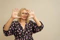 Pretty blonde woman with long hair posing in dark dress on a beige background. Emotional portrait. She makes a scared Royalty Free Stock Photo