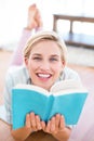 Pretty blonde woman lying on the floor and reading a book Royalty Free Stock Photo