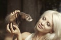 Pretty blonde woman posing with her ferret baby outdoor