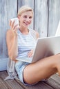 Pretty blonde woman using her laptop and drinking coffee Royalty Free Stock Photo