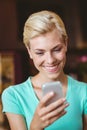 Pretty blonde woman using her smartphone Royalty Free Stock Photo