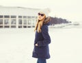 Pretty blonde woman wearing a jacket, hat and sunglasses in winter Royalty Free Stock Photo