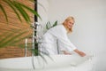 Pretty blonde woman in a white bath robe getting a bath ready Royalty Free Stock Photo