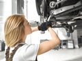 Pretty blonde working at auto service and repairing car Royalty Free Stock Photo