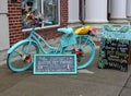 Bright blue bicycle and signs advertising artwork and other items for sale, downtown Saratoga Springs, New York, 2018