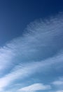 Bright blue skies with wispy white clouds moving across the face of it