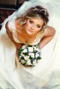 Pretty bride looks up thoughtful holding a bouquet of roses and
