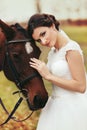 Pretty bride strokes horse`s head