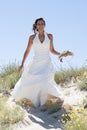 Pretty bride walking along sea coast wearing beautiful wedding dress Royalty Free Stock Photo