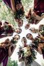 Pretty bridesmaids surround a bride holding wedding bouqeuts in their arms