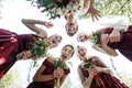 Pretty bridesmaids surround a bride holding wedding bouqeuts in their arms