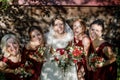 Bride with bridesmaids on the park on the wedding day