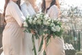 Pretty bridesmaids surround a bride holding wedding bouqeuts in their arms. Wedding. Details