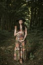 Pretty brunette Caucasian young pregnant woman posing in beautiful forest outdoors Royalty Free Stock Photo