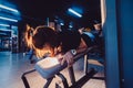 Sportive woman using machine for legs at the gym. Pretty brunette exercising in a simulator. Royalty Free Stock Photo