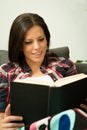 Pretty brunette girl reading on the sofa Royalty Free Stock Photo