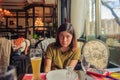 A pretty brunette girl is sitting at a table in a restaurant, in front of her is a glass of beer Royalty Free Stock Photo