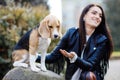 Pretty brunette girl spends time with her favorite cute dog. Girl spends time outdoors with dog, breed beagle