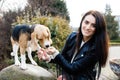 Pretty brunette girl spends time with her favorite cute dog. Girl spends time outdoors with dog, breed beagle