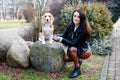 Pretty brunette girl spends time with her favorite cute dog. Girl spends time outdoors with dog, breed beagle