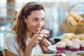 Pretty brunette holding and smelling cupcake Royalty Free Stock Photo