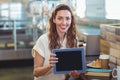 Pretty brunette looking at camera and showing tablet Royalty Free Stock Photo