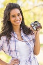 Pretty brunette in the park using retro camera Royalty Free Stock Photo