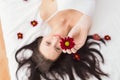 Pretty brunette posing in bed with flowers Royalty Free Stock Photo