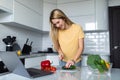 Pretty woman preparing salad and using laptop in the kitchen Royalty Free Stock Photo