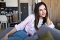 Pretty brunette woman relaxing on the couch at home in the living room Royalty Free Stock Photo