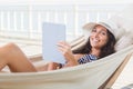 Pretty brunette relaxing on a hammock and using tablet pc Royalty Free Stock Photo