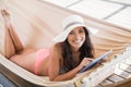 Pretty brunette relaxing on a hammock and using tablet pc Royalty Free Stock Photo