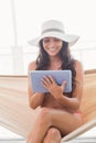 Pretty brunette relaxing on a hammock and using tablet pc Royalty Free Stock Photo