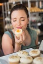 Pretty brunette smelling a cupcake Royalty Free Stock Photo