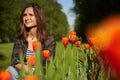 Pretty young student among tulips in spring park