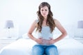 Pretty brunette suffering from stomach pain Royalty Free Stock Photo