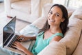 Pretty brunette using her laptop on the couch Royalty Free Stock Photo