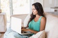 Pretty brunette using her laptop on the couch Royalty Free Stock Photo