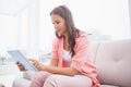 Pretty brunette using her tablet pc on the couch Royalty Free Stock Photo