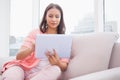 Pretty brunette using her tablet pc on the couch Royalty Free Stock Photo