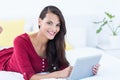 Pretty brunette using her tablet pc lying on her bed Royalty Free Stock Photo