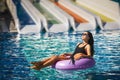 Pretty brunette woman in bikini in the swimming pool