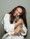 Pretty brunette woman cuddling pet cat