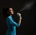 Pretty brunette woman doctor gynecologist nurse in latex gloves and medical uniform gown uses disinfectant spray Royalty Free Stock Photo