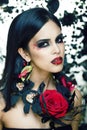 Pretty brunette woman with rose jewelry, black and red, bright make up a vampire closeup red lips Royalty Free Stock Photo