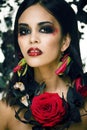 Pretty brunette woman with rose jewelry, black and red, bright make up kike a vampire closeup red lips Royalty Free Stock Photo