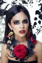 pretty brunette woman with rose jewelry, black and red, bright make up kike a vampire closeup red lips Royalty Free Stock Photo