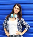 Pretty brunette woman wearing a checkered shirt with headphones over blue Royalty Free Stock Photo